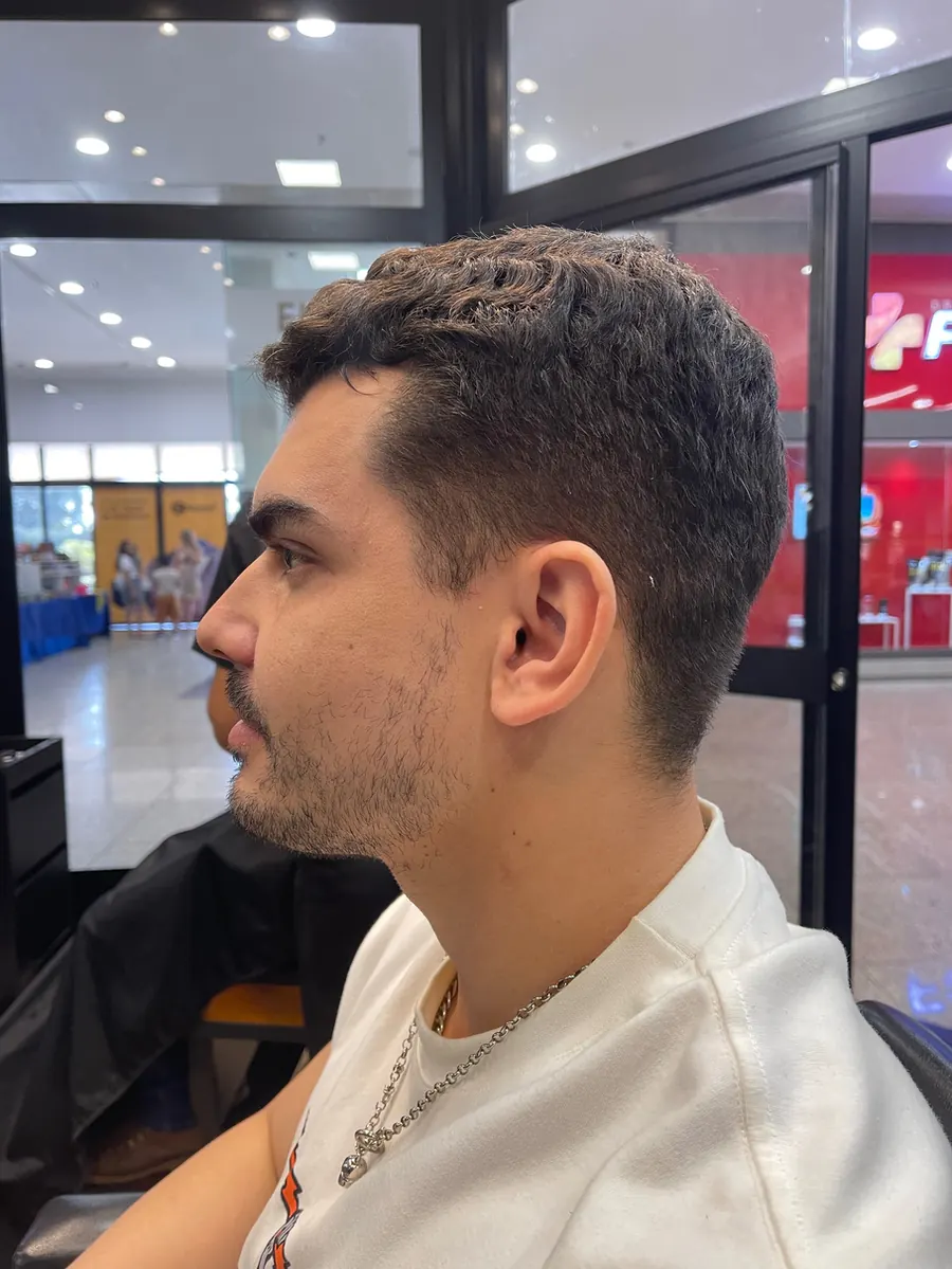 Cliente de perfil antes da consultoria, com o cabelo cacheado curto e sem finalização